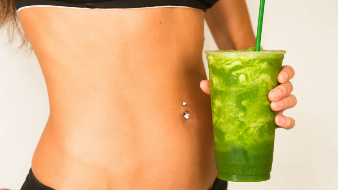 women holding a green smoothie