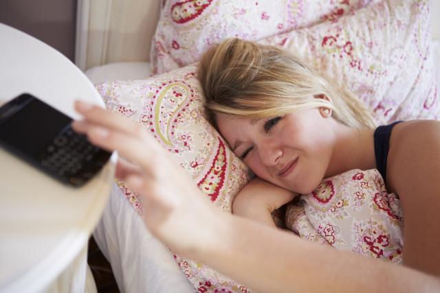 Woman turning off phone before going to sleep