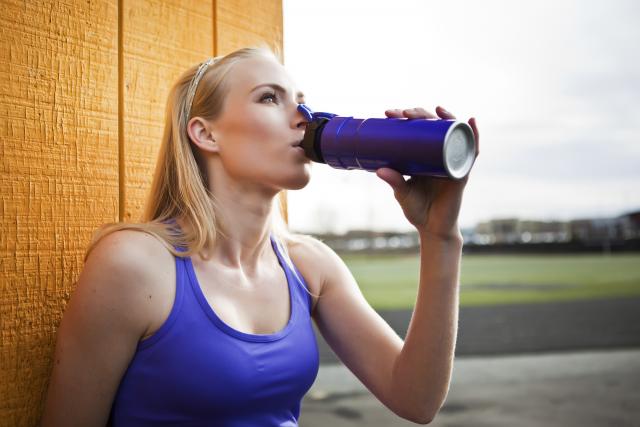Woman in gym clothes drinking water