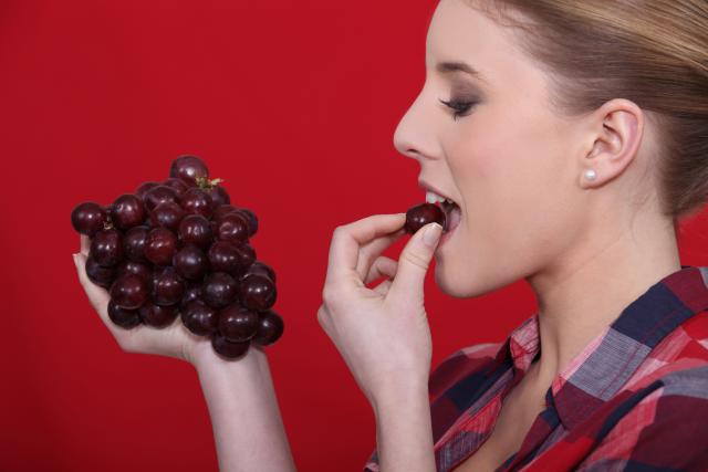 Woman eating grapes