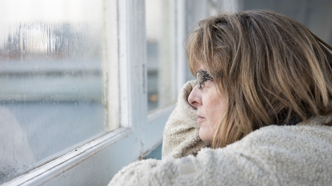 Woman looks out window