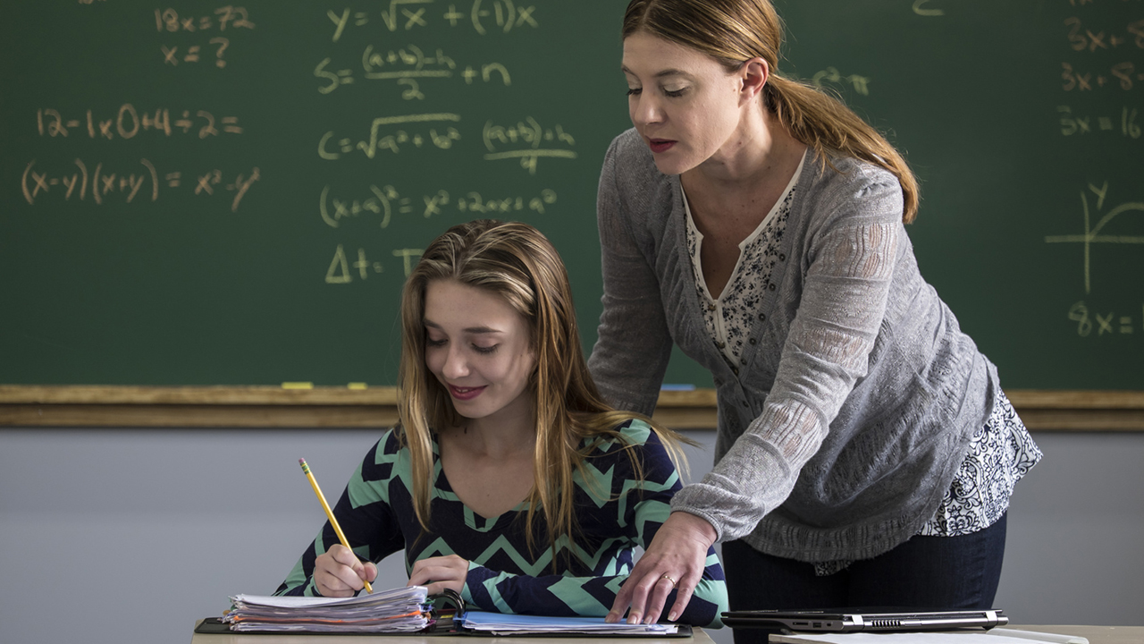 Female teacher helping a young female student