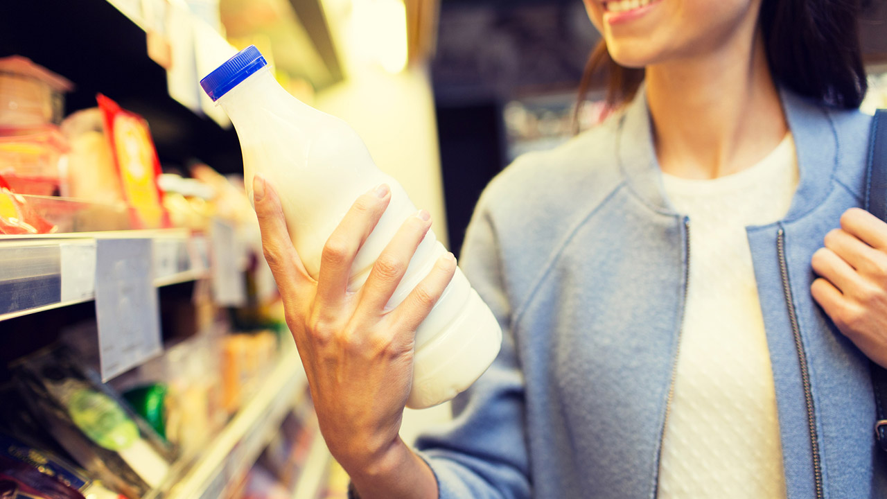 Woman with bottle of milk in market